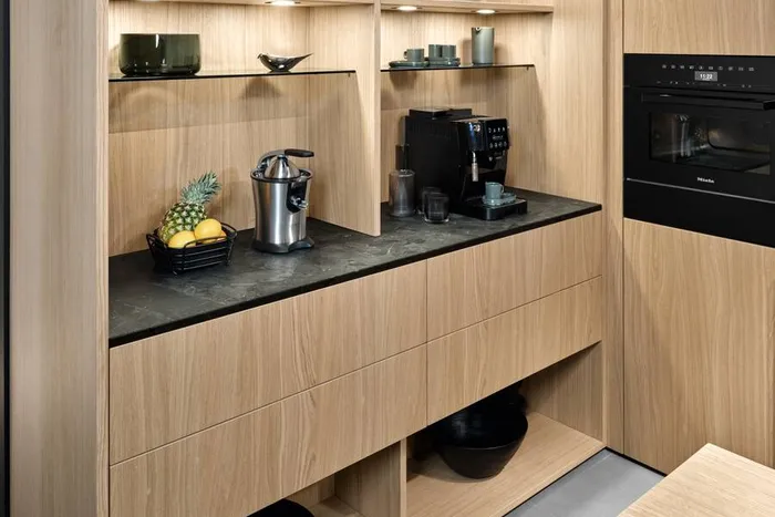 Moderne Küchenzeile mit Holzfronten, schwarzen Geräten und eingebauten Regalen