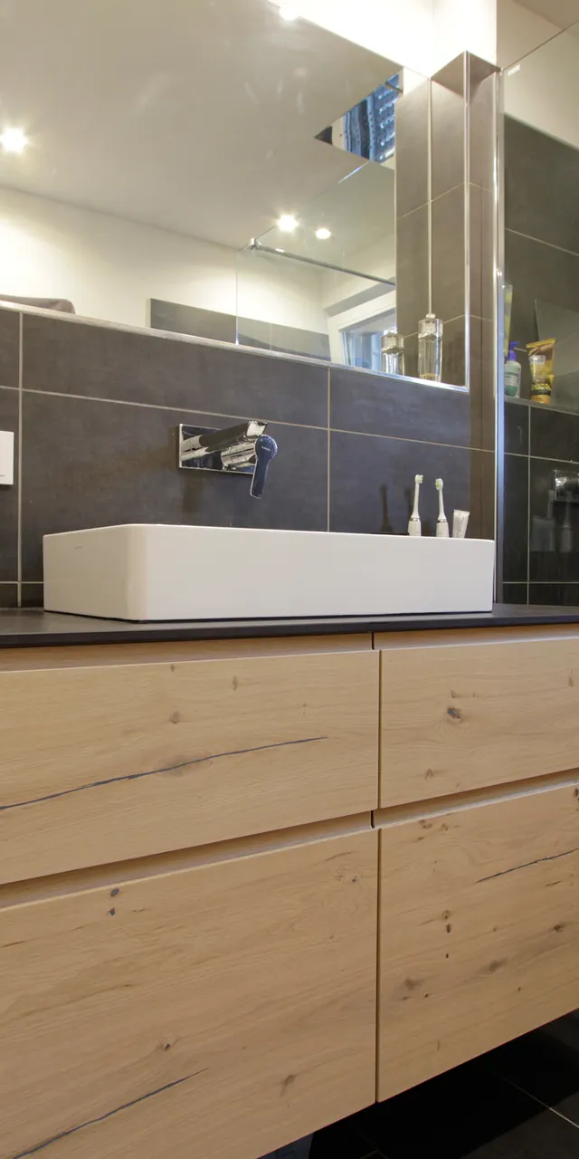 Modernes Badezimmer mit Holzwaschtisch, Glasdusche und Waschmaschine