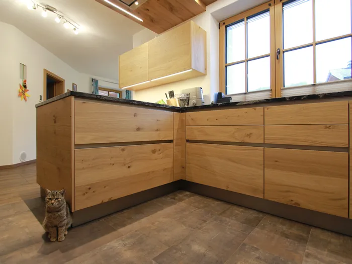 Grifflose Holzküche mit schwarzen Griffmulden