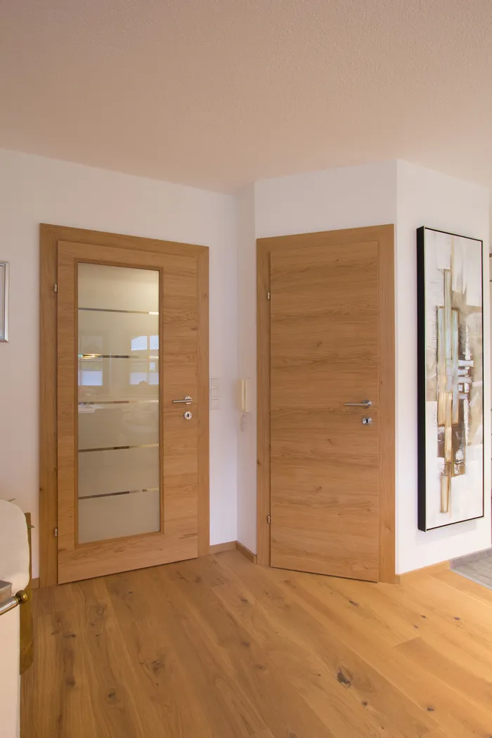 Innenflur mit zwei Holztüren und Parkettboden in moderner Wohnungseinrichtung