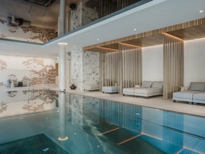 Luxuriöser Innenpool mit Liegebetten, dekorativen Wänden und entspannter Spa-Atmosphäre