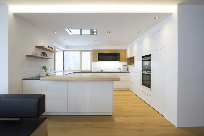 Weiße moderne Küche mit Bar und Holz