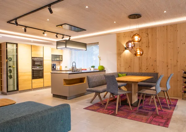Moderne offene Küche mit Holzfronten, Essbereich und Designlampen