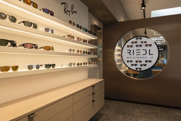 Moderne Sonnenbrillenauslage mit Ray-Ban und Riedl Meisteroptik im Brillengeschäft