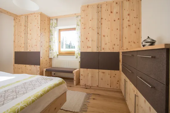 Modernes Schlafzimmer mit maßgefertigten Zirbenholzmöbeln und braunen Fronten