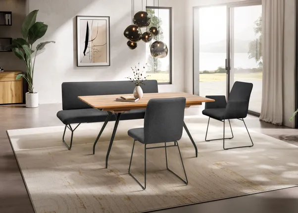 Modernes Esszimmer mit Holztisch, grauen Stühlen und großen Fenstern mit Seeblick