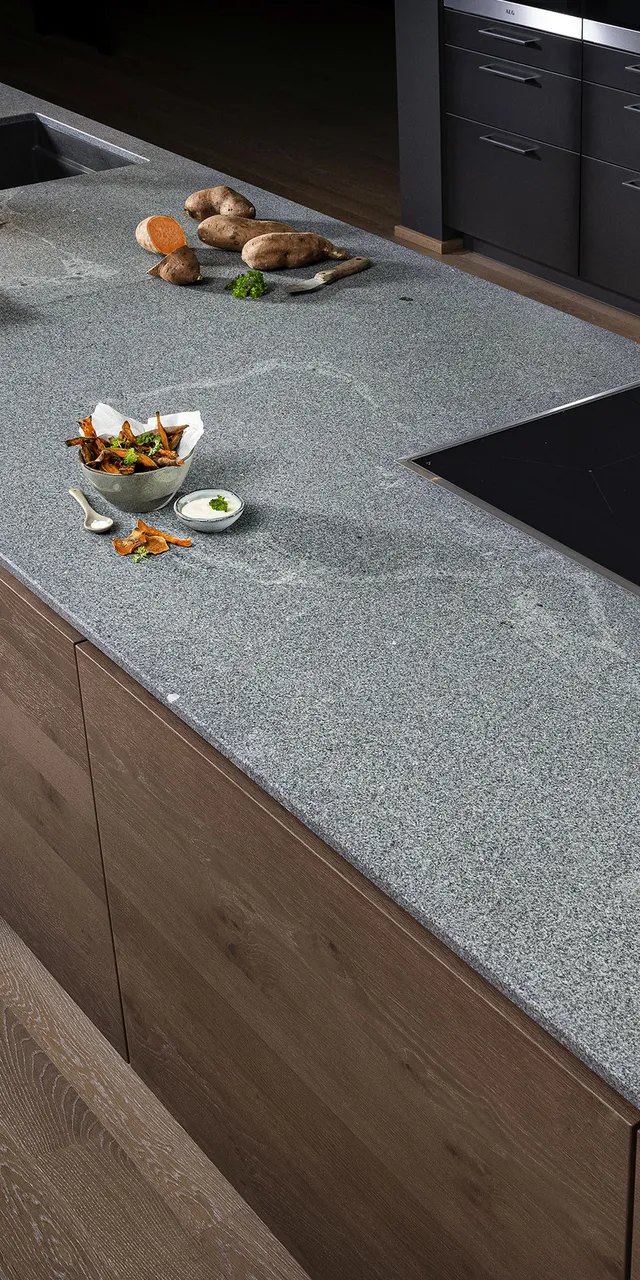 Moderne Kücheninsel mit grauer Steinplatte, Induktionskochfeld und integriertem Spülbecken