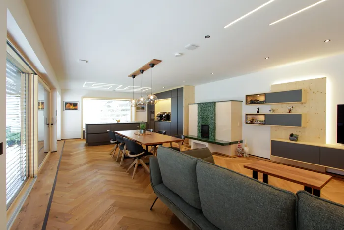 Modernes offenes Wohnzimmer mit Holzboden, Essbereich und stilvollem Kamin