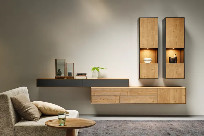 Modernes Wohnzimmer mit schwebenden Holzmöbeln, grauem Sofa und minimalistischer Dekoration