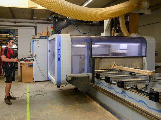 Arbeiter bedient CNC-Fräsmaschine BMG 511 in moderner Tischlerwerkstatt