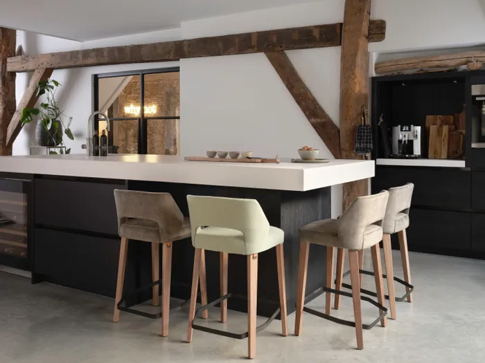 Moderne Küche mit großer Kochinsel, Barhockern und freiliegenden Holzbalken