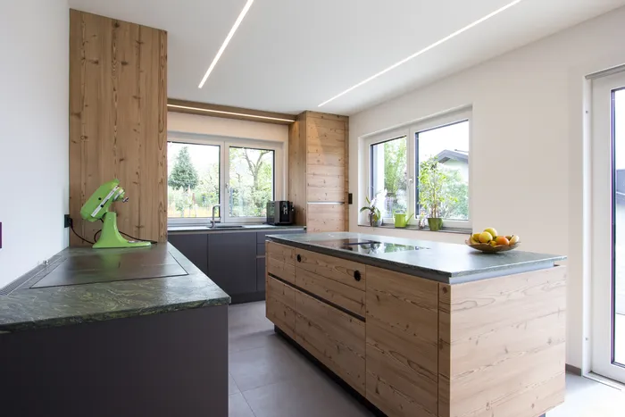 Moderne Küche mit grüner Küchenmaschine, Holzfronten und Naturstein-Arbeitsplatte