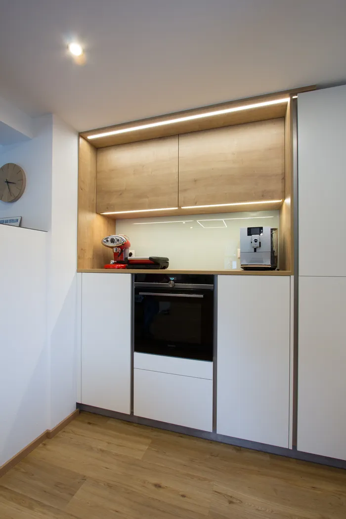 Moderne Einbauküche mit Kaffeemaschinen, Holzdetails und LED-Beleuchtung