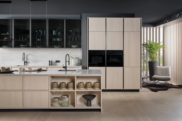 Moderne offene Küche mit hellem Holz, Kochinsel und schwarzen Armaturen