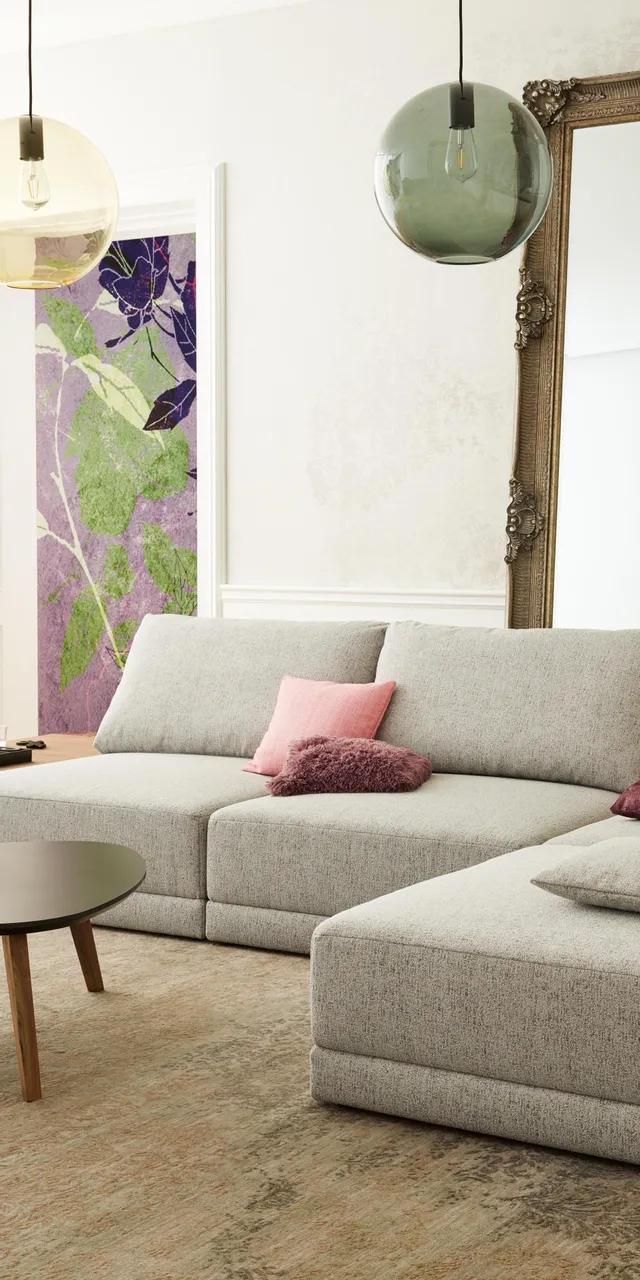 Modernes Wohnzimmer mit grauem Ecksofa, bunten Kissen und großem Spiegel an der Wand