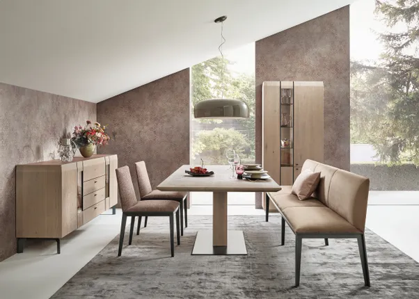 Modernes Esszimmer mit Esstisch, Bank, Stühlen und Holz-Sideboard vor großen Fenstern