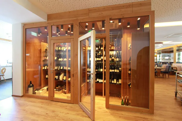 Moderner Weinschrank mit Glasfront und zahlreichen Weinflaschen in einem eleganten Restaurant