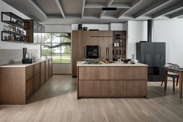 Moderne Küche mit Holzfronten, Kochinsel und großen Fenstern mit Blick ins Grüne