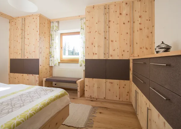 Modernes Schlafzimmer mit maßgefertigten Zirbenholzmöbeln und braunen Fronten