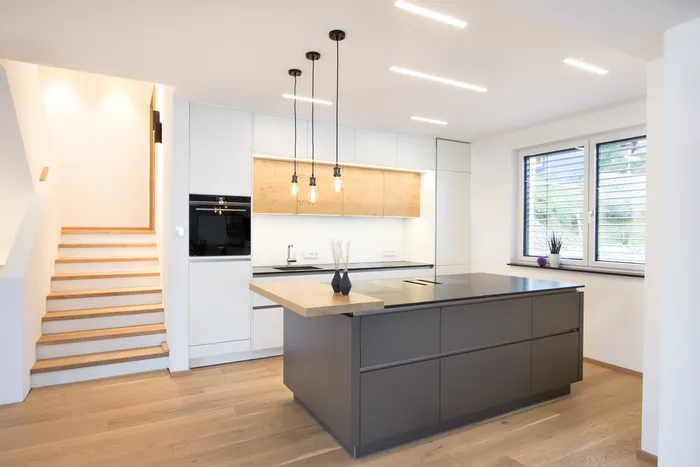 Moderne Küche mit grauer Insel und Weiß mit Holz