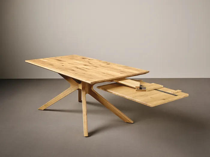 Ausziehbarer Holztisch mit modernem Design und schrägen Beinen auf grauem Hintergrund