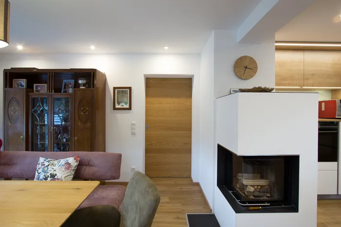 Modernes Wohnzimmer mit Kamin, Holzmöbel und Glasausstellungsschrank