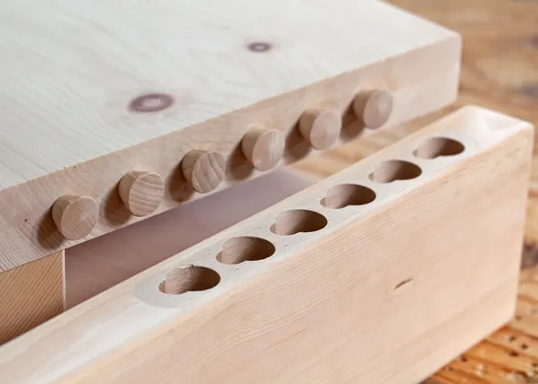 Holzverbindung mit Runddübeln in massiven Holzbrettern auf Werkbank