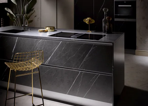 Moderne schwarze Küche mit Marmorarbeitsplatte und goldenem Drahtstuhl