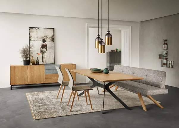 Modernes Esszimmer mit Holztisch, grauer Polsterbank, Designerstühlen und Hängelampen im skandinavischen Stil