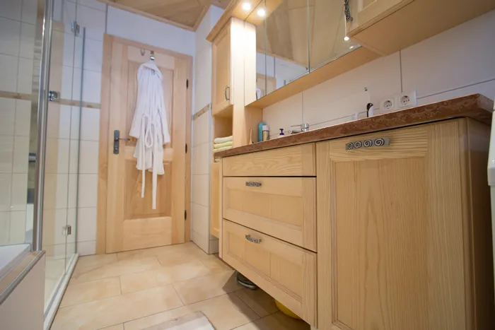 Modernes Badezimmer mit Holzmöbeln, Spiegelschrank und Duschkabine