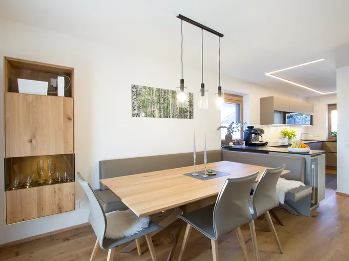 Moderne Wohnküche mit Essbereich, Holzstuhlmöbeln und Hängelampen im skandinavischen Stil