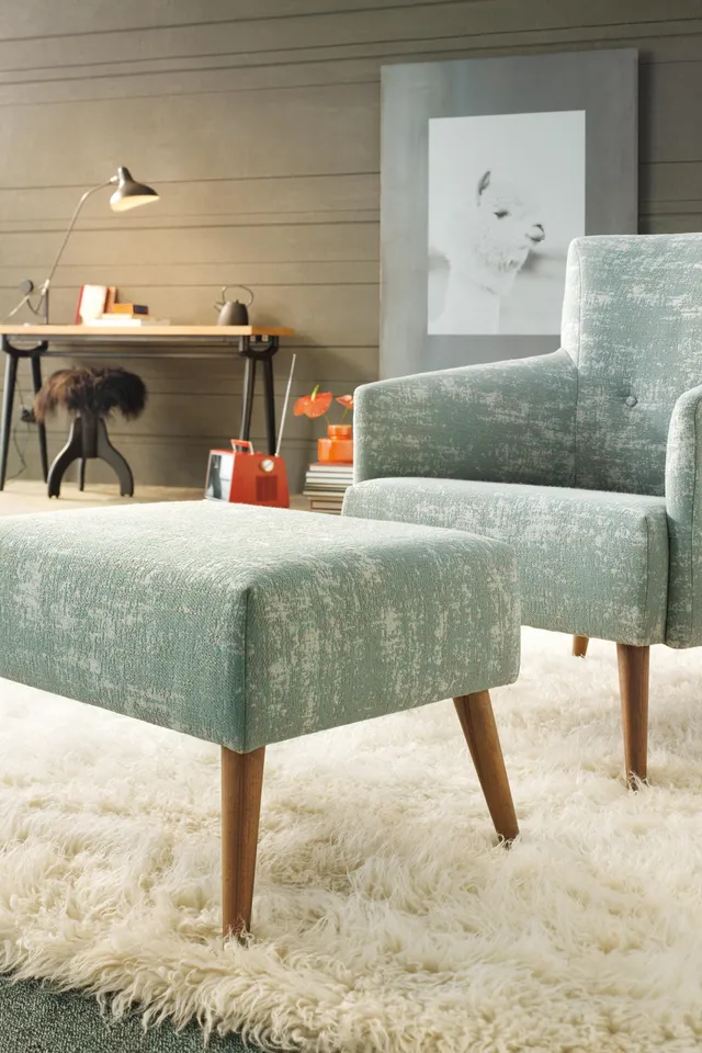 Modernes Wohnzimmer mit mintgrünem Sessel, Hocker und flauschigem Teppich