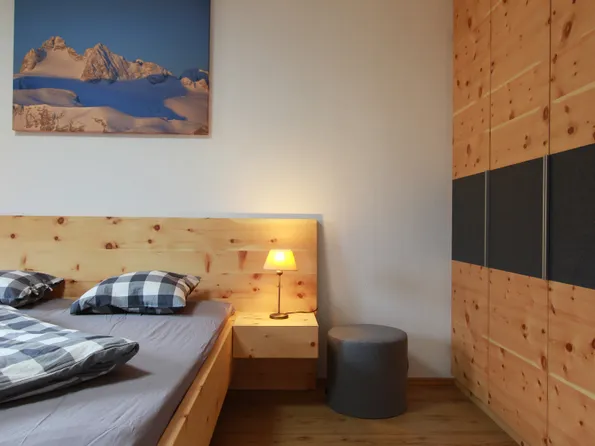 Modernes Schlafzimmer mit Holzbett, Nachttischlampe und Einbauschrank aus Holz