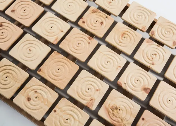 Holzlattenrost mit quadratischen, spiralförmig geschnitzten Elementen aus Naturholz