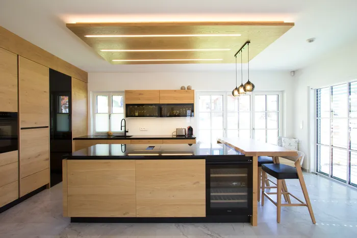 Moderne offene Küche mit Holzfronten, Kochinsel, Weinkühlschrank und Hängelampen