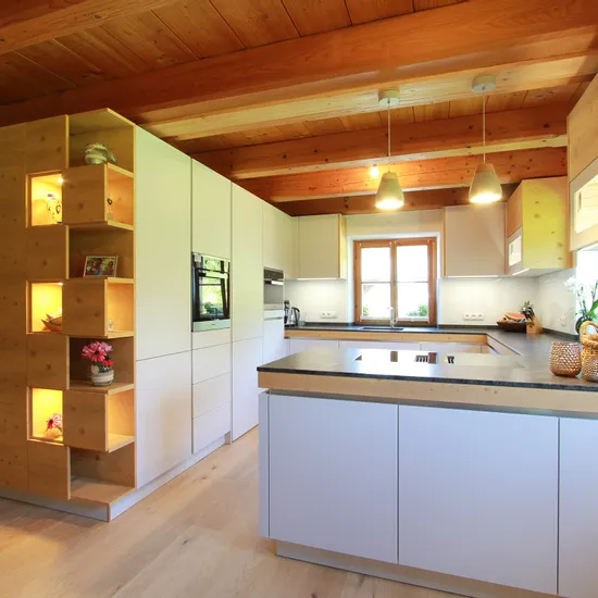 Moderne offene Küche mit Holzdecke, Kochinsel und integriertem Regal mit Beleuchtung