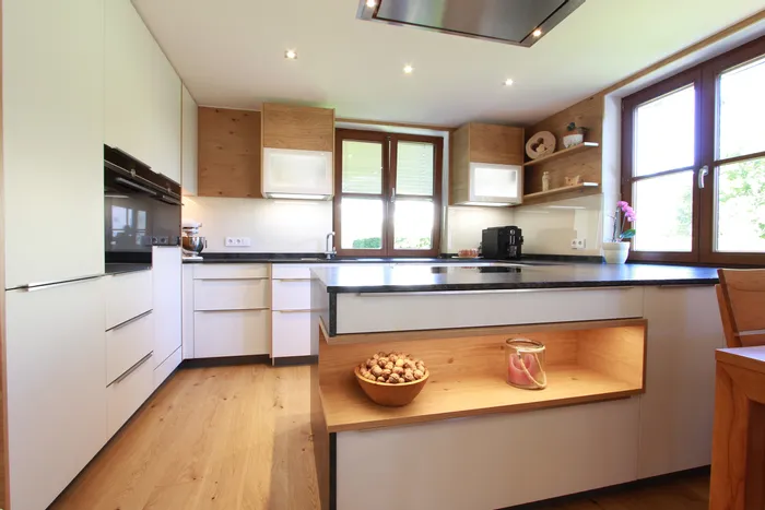 Moderne Einbauküche mit Kochinsel, Holzdetails und großen Fenstern für Tageslicht