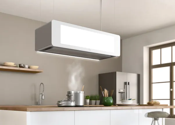 Moderne Dunstabzugshaube über Kochinsel in heller, minimalistischer Küche