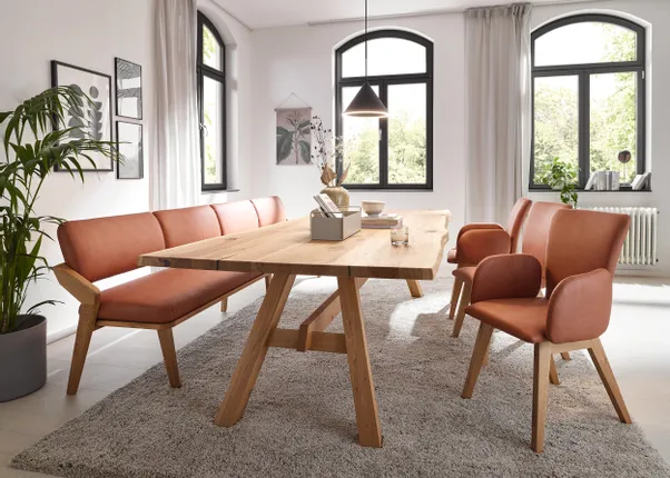 Helles Esszimmer mit Holztisch, braunen Polsterstühlen und modernen Dekoelementen