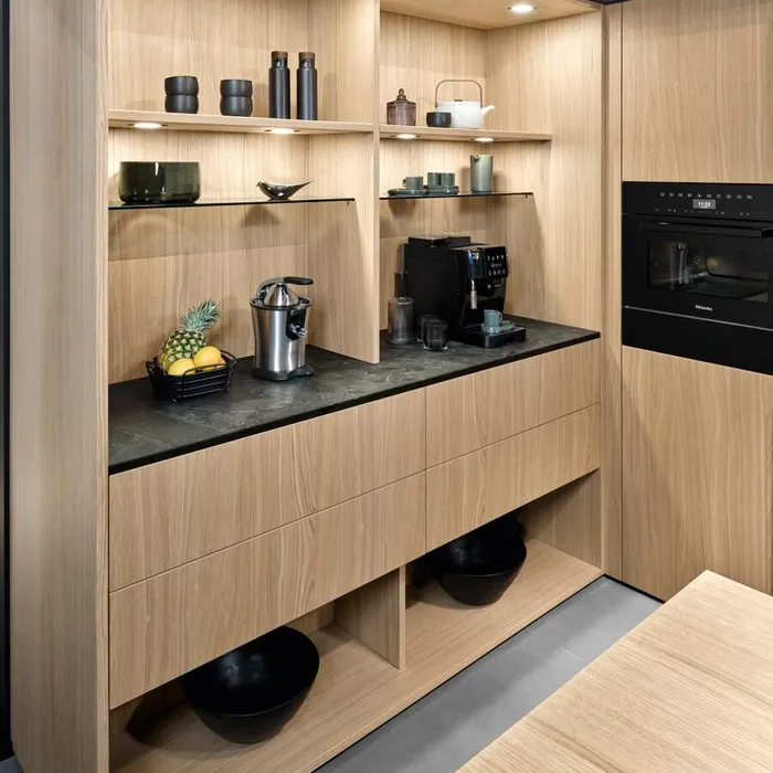 Moderne Küchenzeile aus hellem Holz mit Kaffeemaschine, Entsafter und offenem Regaldesign
