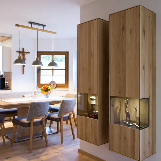 Moderne Esszimmerküche mit Holzmöbeln, grauen Stühlen und dekorativen Hängeleuchten