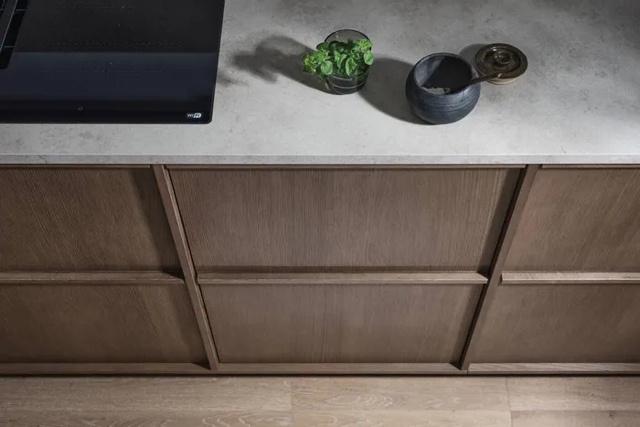 Moderne Küchenzeile mit grauer Arbeitsplatte, Kräutertopf und Kochfeld mit WLAN-Funktion