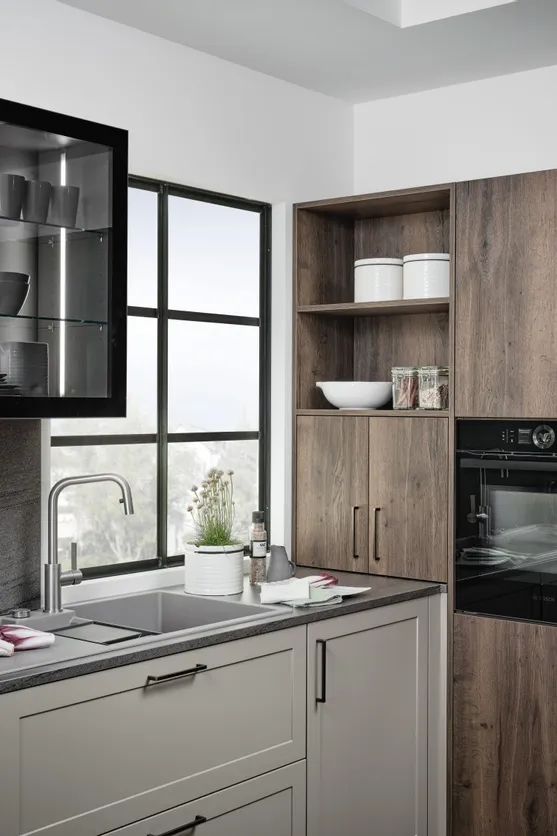 Moderne Küche mit dunklen Holzschränken, Glasvitrine und integriertem Backofen