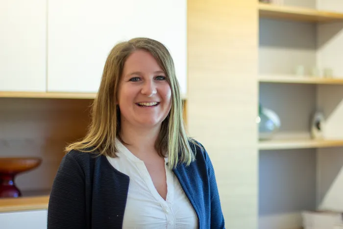 Lächelnde Frau mit blonder, schulterlanger Frisur in Büroeinrichtung