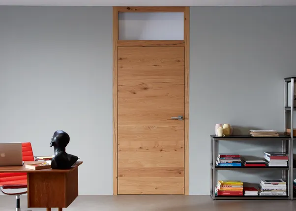 Moderne Holztür in einem Arbeitszimmer mit Schreibtisch, rotem Stuhl und Bücherregalen