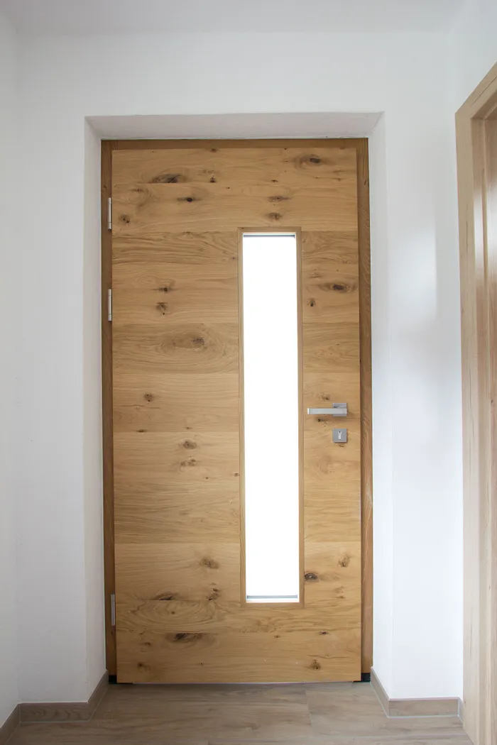 Moderne Holztür aus Eiche mit vertikalem Glaseinsatz im Innenbereich