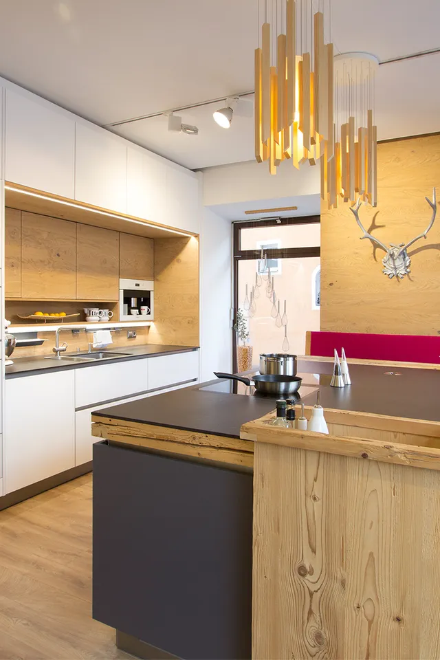 Moderne Einbauküche mit Holzverkleidung, Kücheninsel und gemütlicher Sitzecke mit Wanddeko