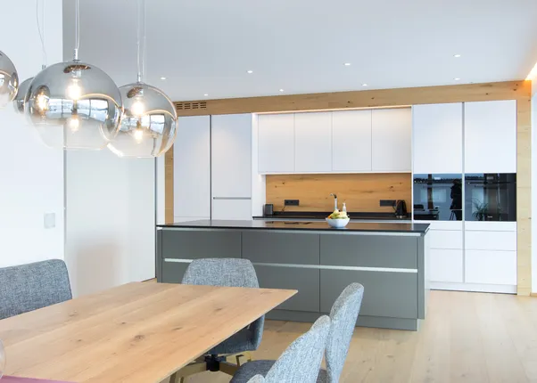 Moderne offene Küche mit Holzdetails, Kücheninsel, Esstisch und Hängelampen