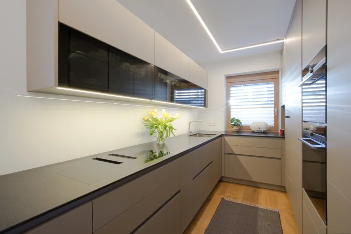 Moderne Einbauküche mit grauen Fronten, Induktionskochfeld und LED-Beleuchtung