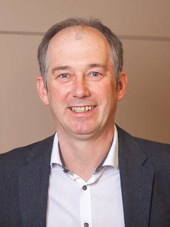 Lächelnder Geschäftsmann in Anzug in modernem Bürointerieur